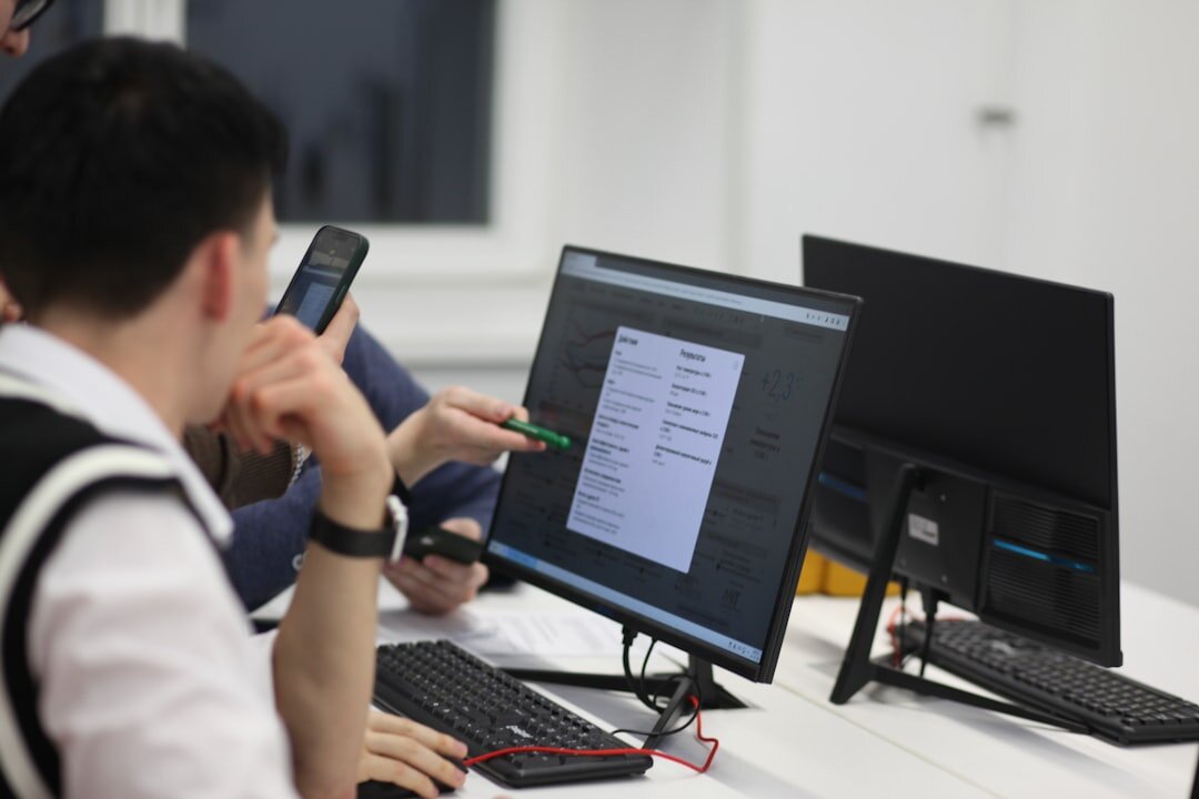 Data analyst studying colorful analytics dashboards on multiple computer screens